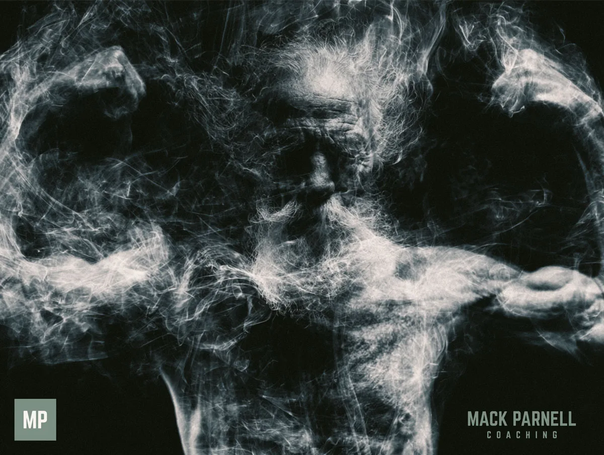 A bearded man flexing both arms, his body formed from pale smoke against a black background